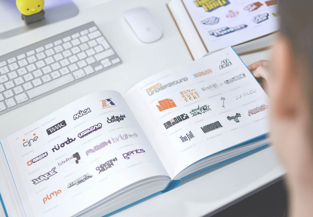 Designer looking through Los Logo book for brand building inspiration